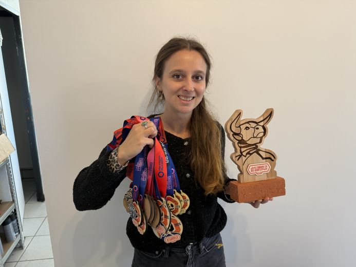 Léa Lévi avec les médailles et un trophée que son entreprise ont créé pour les courses du marathon de Toulouse.