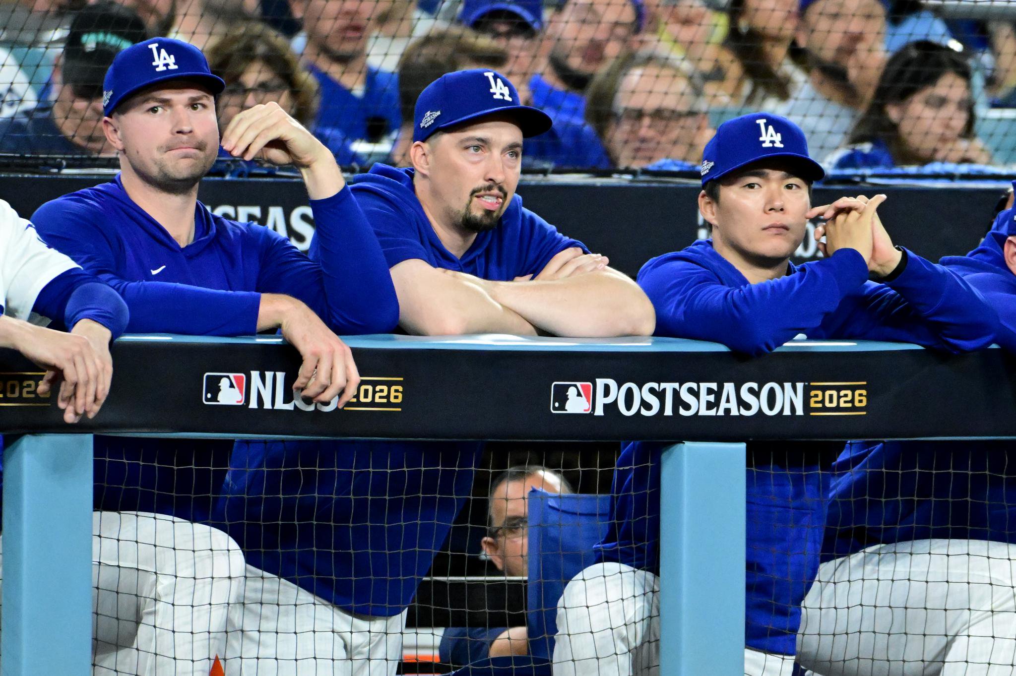 Los Angeles Dodgers players sit in the dugout watching the game.