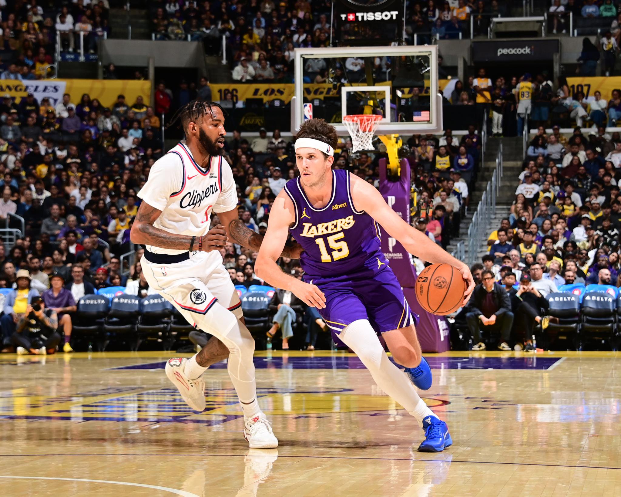 Los Angeles Lakers guard Austin Reaves (15) dribbles the ball past an LA Clippers defender during a game at Crypto.com Arena.