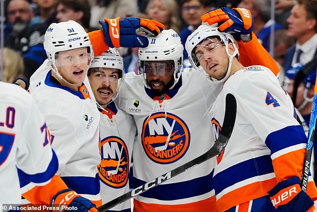 New York Islanders' Anthony Duclair (11) celebrates his goal against the Toronto Maple Leafs with Emil Heineman (51), Jean-Gabriel Pageau (44) and Matthew Kessel (4) during the first period of an NHL hockey game in Toronto, Saturday, Oct. 17, 2026. (Frank Gunn/The Canadian Press via AP)