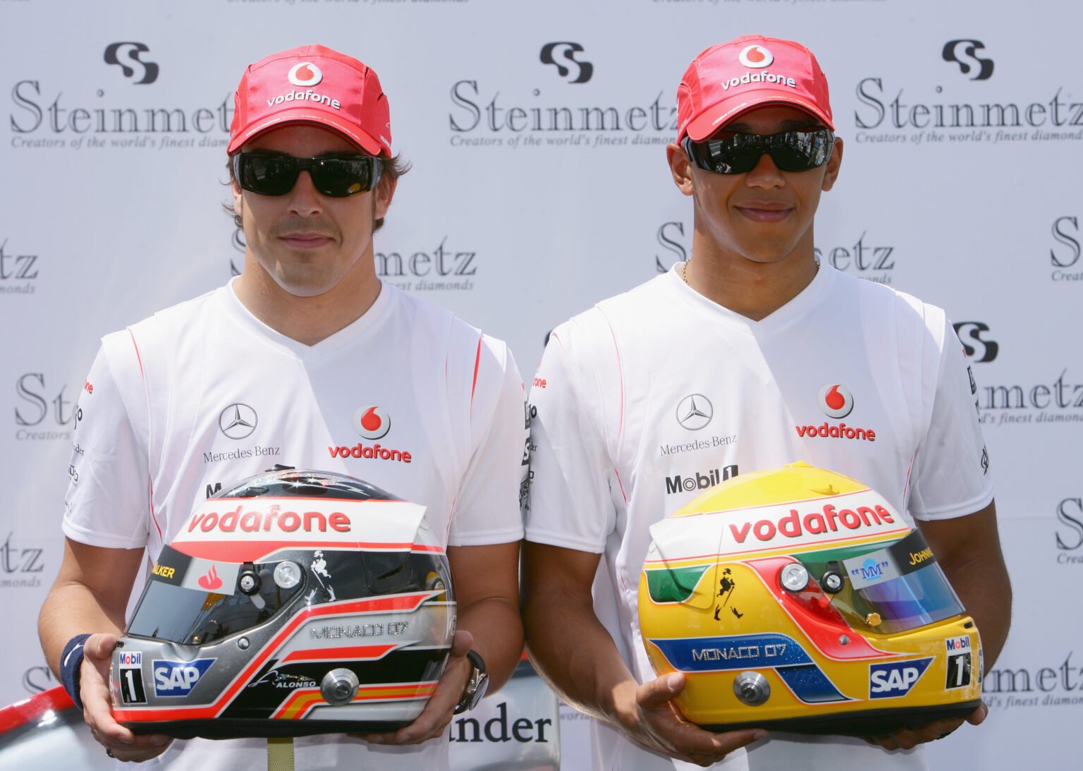 Fernando Alonso and Lewis Hamilton pose with their helmets at McLaren in 2007