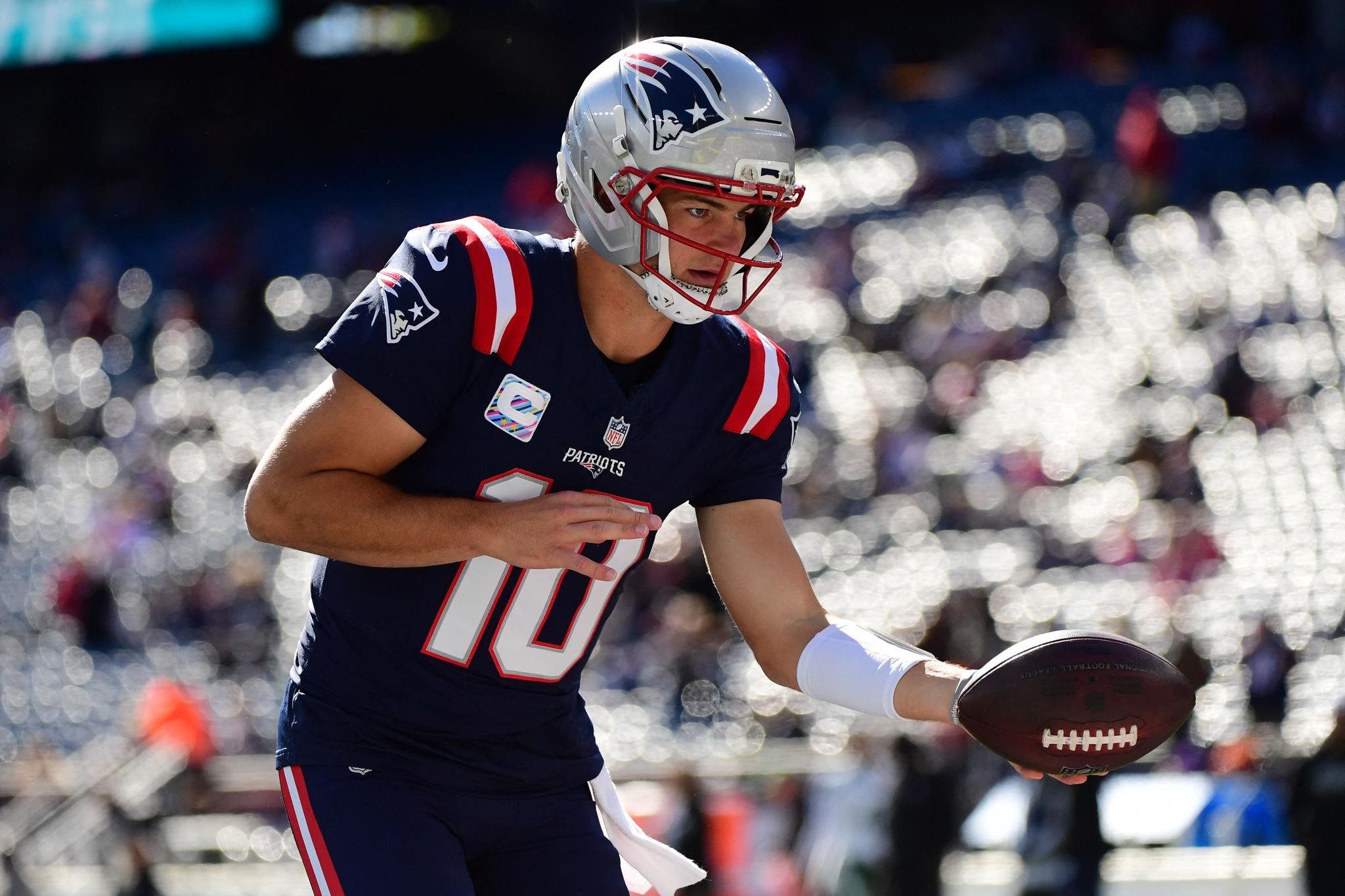 New England Patriots quarterback Drake Maye (10) hands the ball off during warmups prior to a game against the New York Jets.