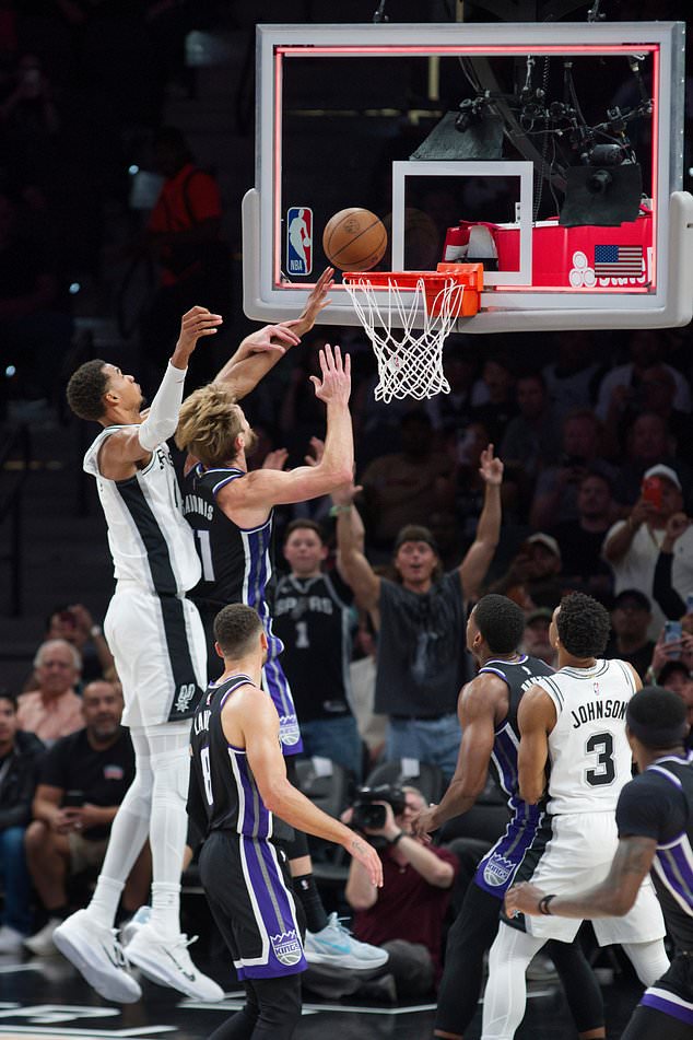 San Antonio Spurs center Victor Wembanyama, left, goes to the basket against Sacramento Kings center Domantas Sabonis (11) at the end of the first half of an NBA basketball game, Tuesday, Oct. 27, 2026, in San Antonio. (AP Photo/Darren Abate)