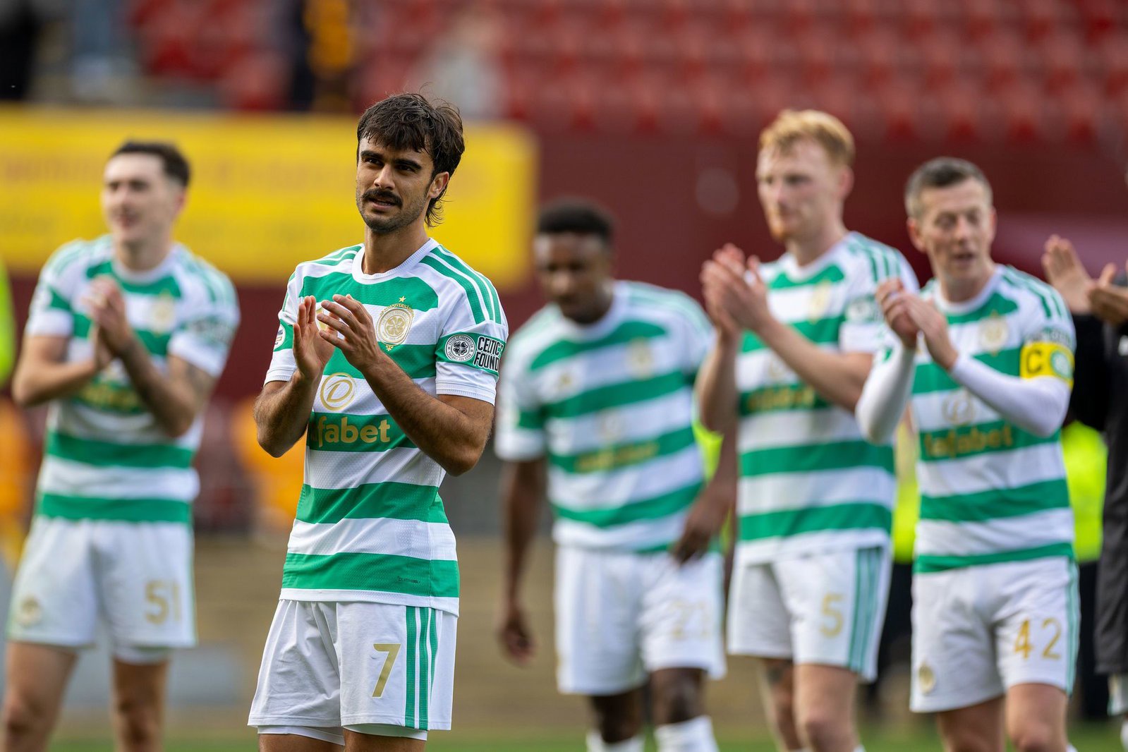 Jota and Callum McGregor applaud the Celtic fans at full time