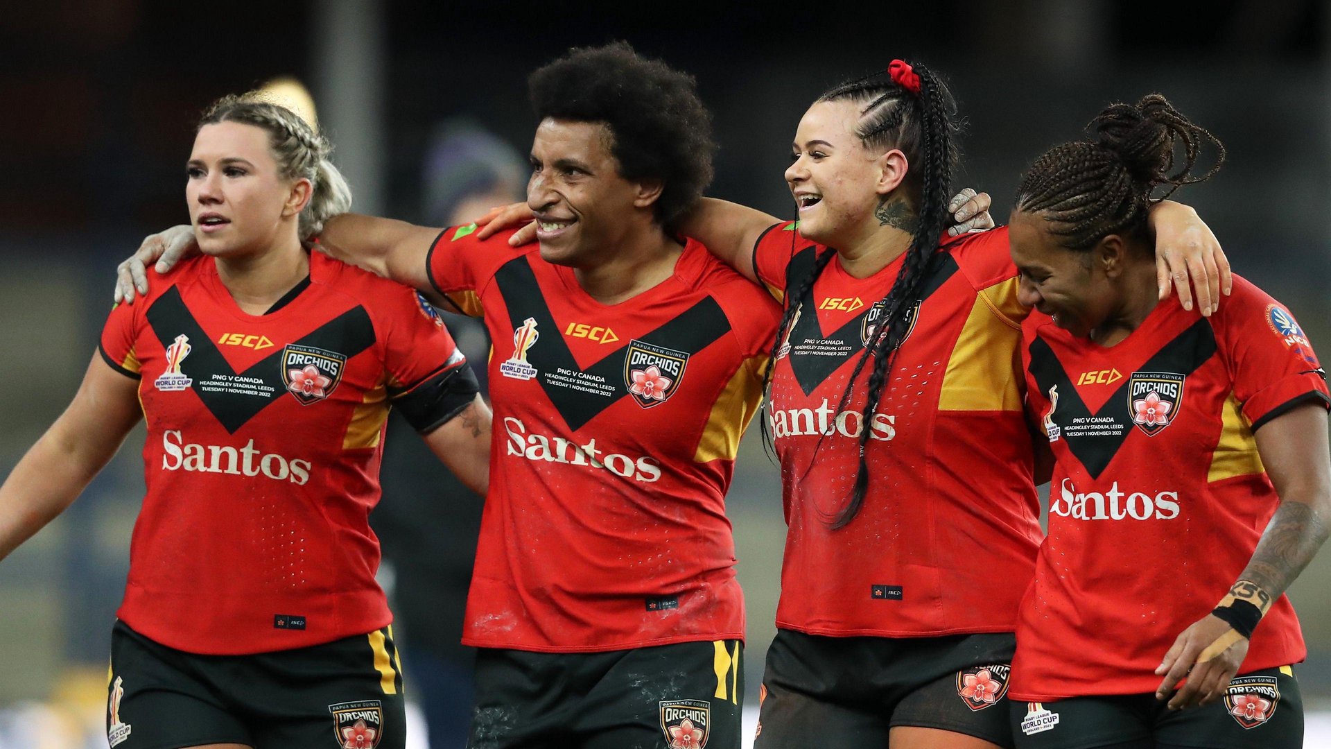 Four Papua New Guinea players link in a row, arms around each other's shoulders