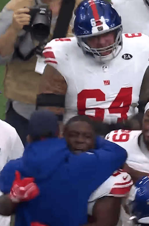 John Harbaugh is tackled by Devin Singletary after the Giants' win.