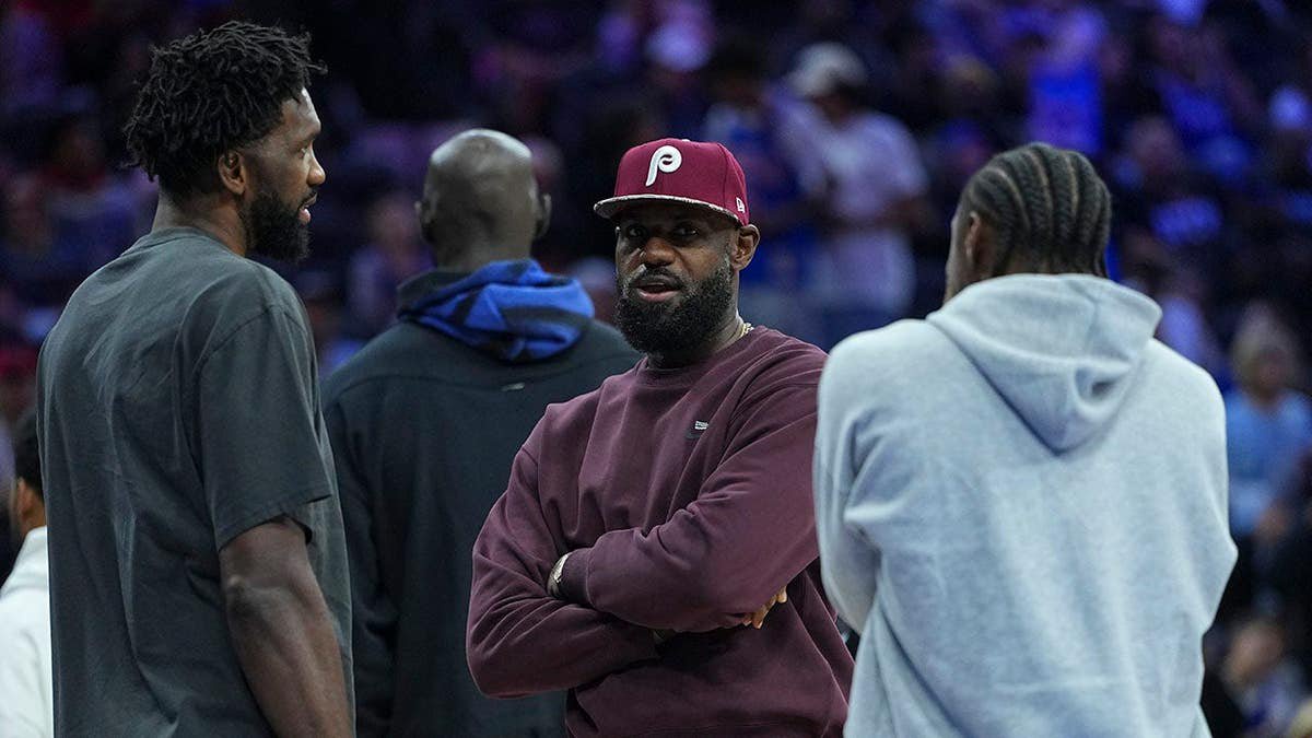 LeBron James talks to Joel Embiid and Tyrese Maxey during a preseason game