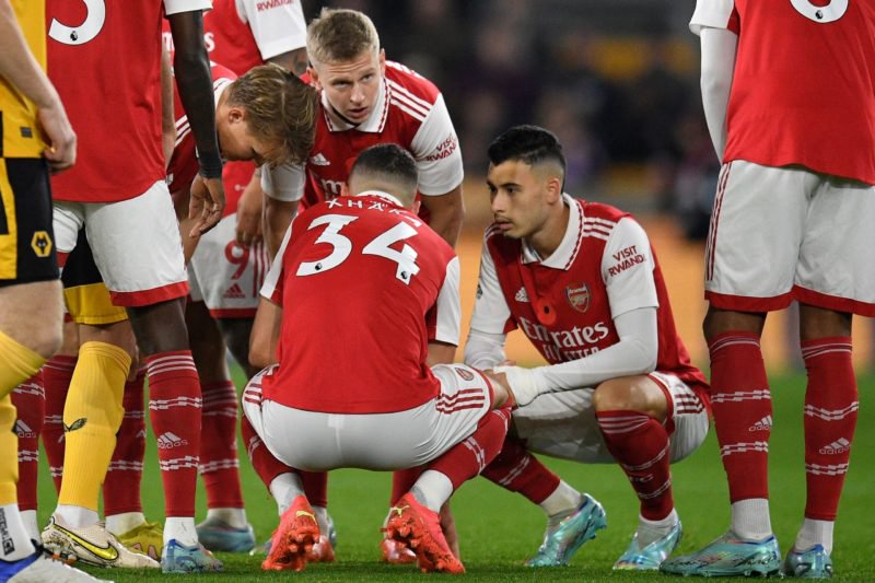 Arsenal players stand around Arsenal's Swiss midfielder Granit Xhaka during the English Premier League football match between Wolverhampton Wanderers and Arsenal at the Molineux stadium in Wolverhampton, central England on November 12, 2022. (Photo by OLI SCARFF/AFP via Getty Images)