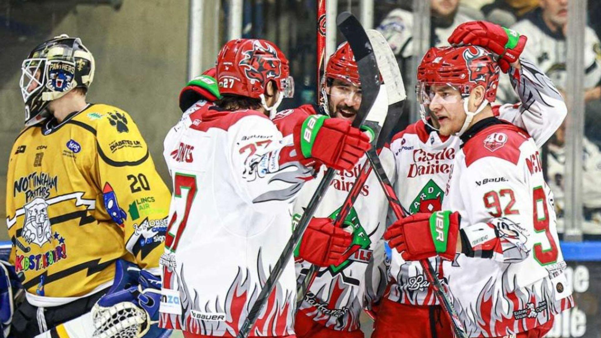 Devils players in red and white celebrate alongside a disconsolate Nottingham Panthers netminder in gold.
