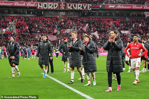 Freiburg's players walk in coats disappointed to their fans after losing the German Bundesliga soccer match between Bayer Leverkusen and SC Freiburg in Leverkusen, Germany, Sunday, Oct. 18, 2026. (AP Photo/Martin Meissner)