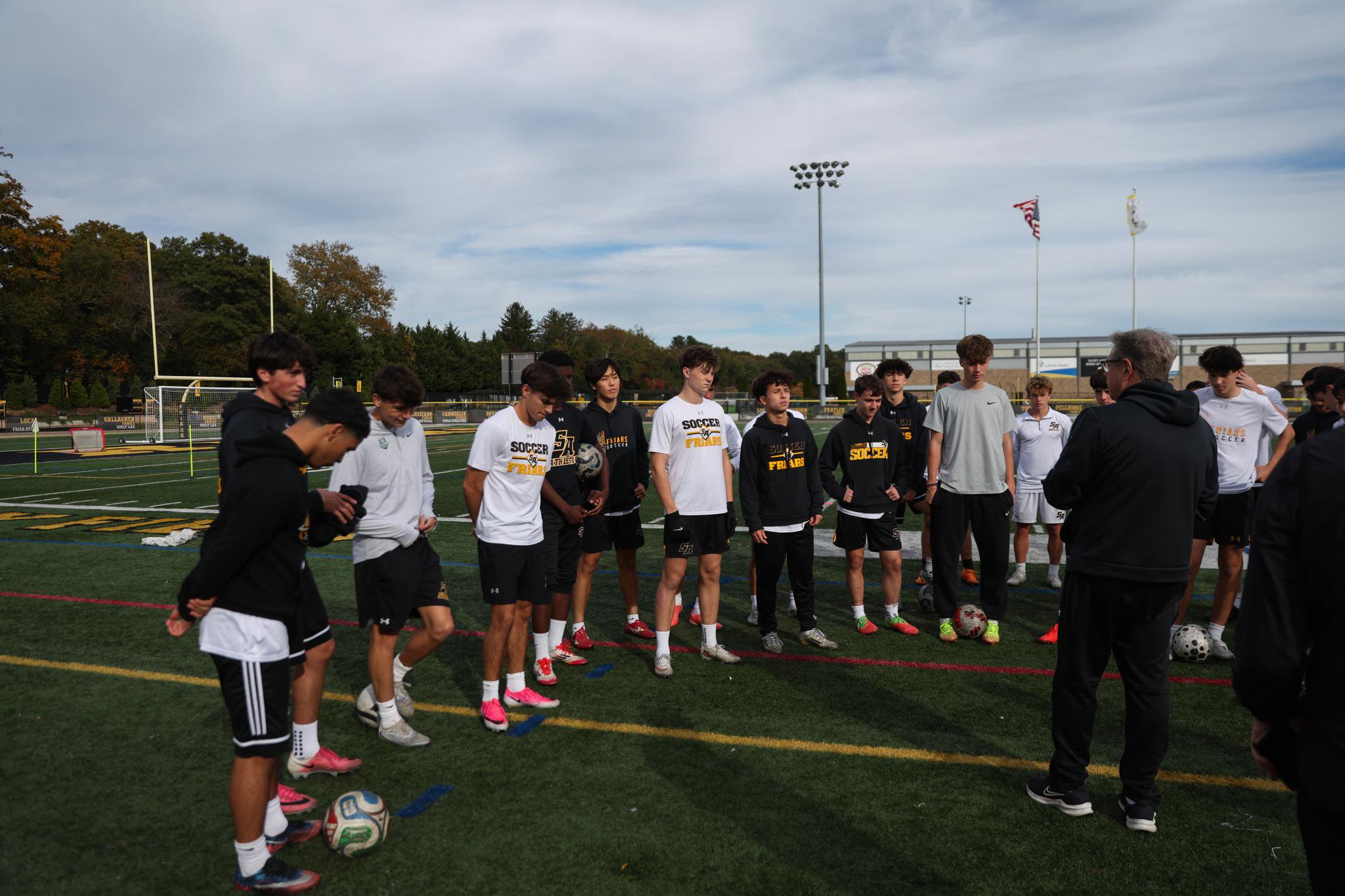 Players on the St. Anthony's boys soccer team listen to their coaches during practice.