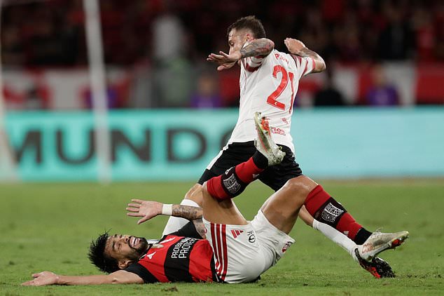 Lucas Paqueta of Brazil's Flamengo falls to the ground while fighting for a ball with Lucas Piovi of Argentina's Estudiantes de La Plata during the second leg of a Copa Libertadores semifinal soccer match in Rio de Janeiro, Thursday, Oct. 22, 2026. (AP Photo/Bruna Prado)