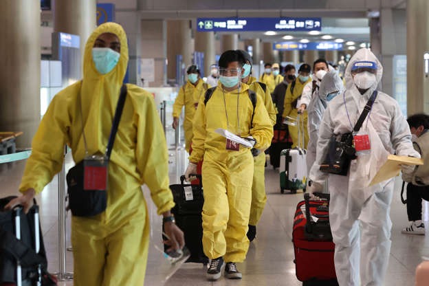 Passengers wearing protective gear arrive at Incheon International Airport in South Korea. Health authorities have imposed an entry ban on foreign arrivals from eight African countries, including South Africa, to block the spread of the new Covid-19 variant <a class=