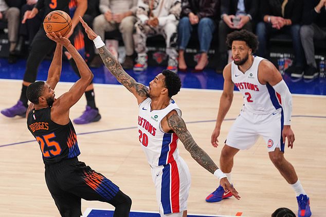 New York Knicks' Mikal Bridges (25) shoots over Detroit Pistons' John Collins (20) as Cade Cunningham (2) watches during the first half of an NBA basketball game Tuesday, Oct. 27, 2026, in New York. (AP Photo/Frank Franklin II)