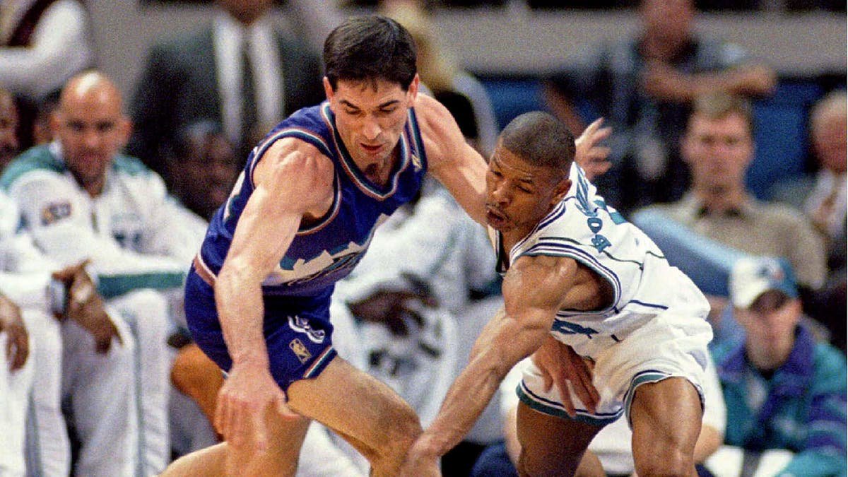 Muggsy Bogues steals the ball from John Stockton during an NBA game at Charlotte Coliseum.