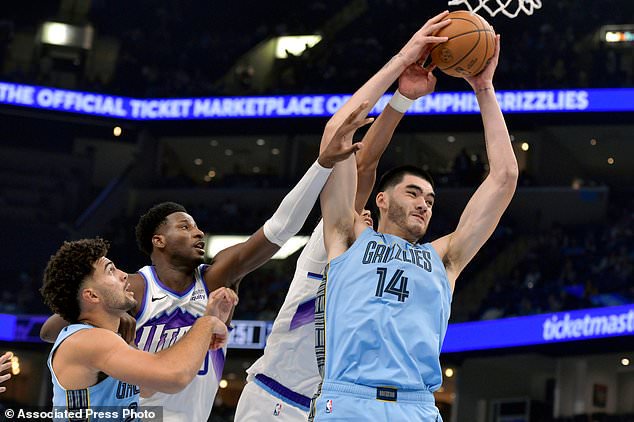 Memphis Grizzlies center Zach Edey (14) grabs a rebound ahead of, from left, guard Jahmai Mashack, Utah Jazz forward Jaren Jackson Jr., and center Jaxson Hayes in the first half of an NBA basketball game Wednesday, Oct. 21, 2026, in Memphis, Tenn. (AP Photo/Brandon Dill)