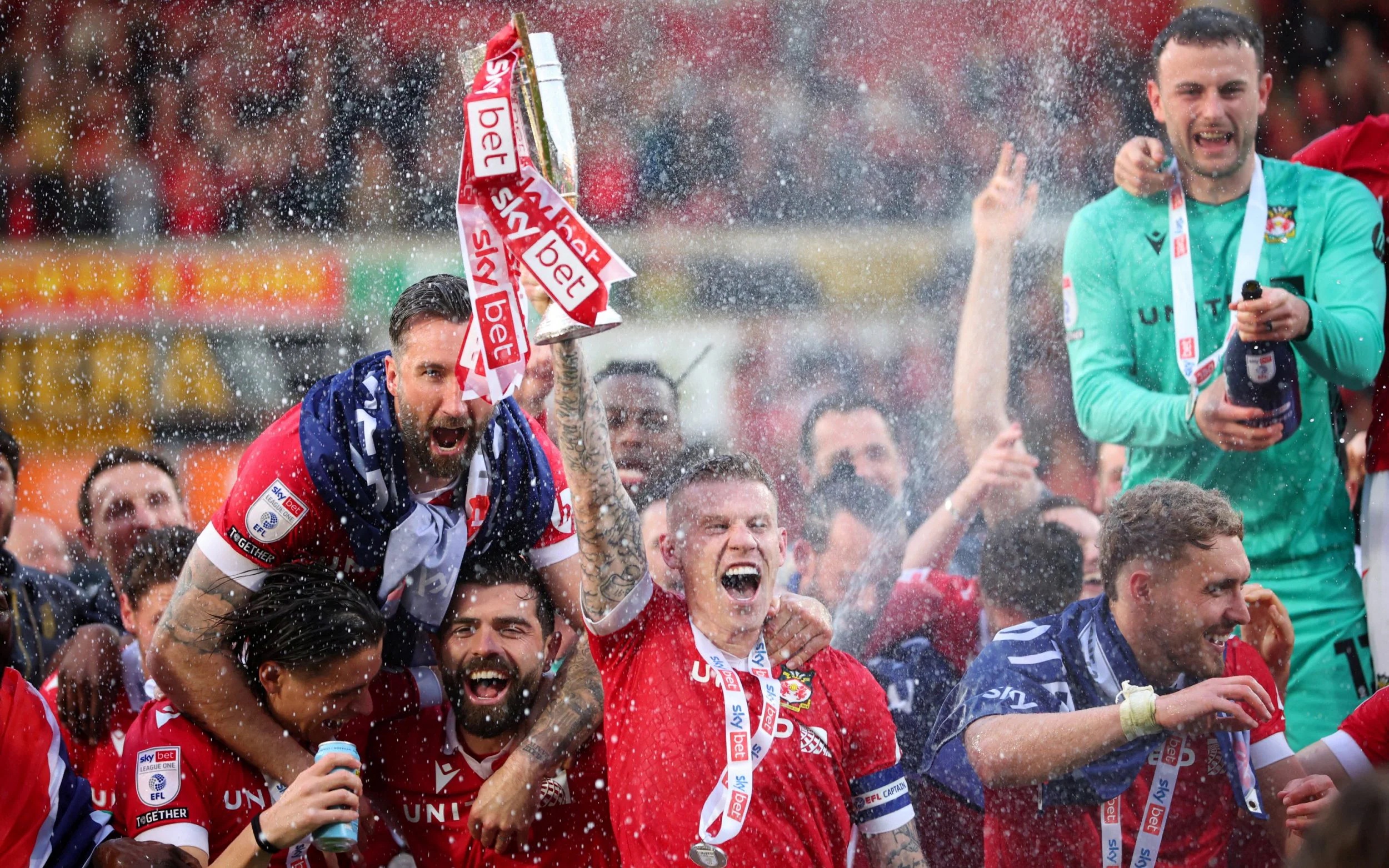 Wrexham's James McClean and teammates celebrate with the trophy