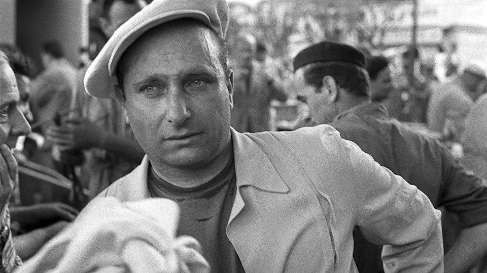 Juan Manuel Fangio pictured wearing a beret at the 1956 Monaco Grand Prix