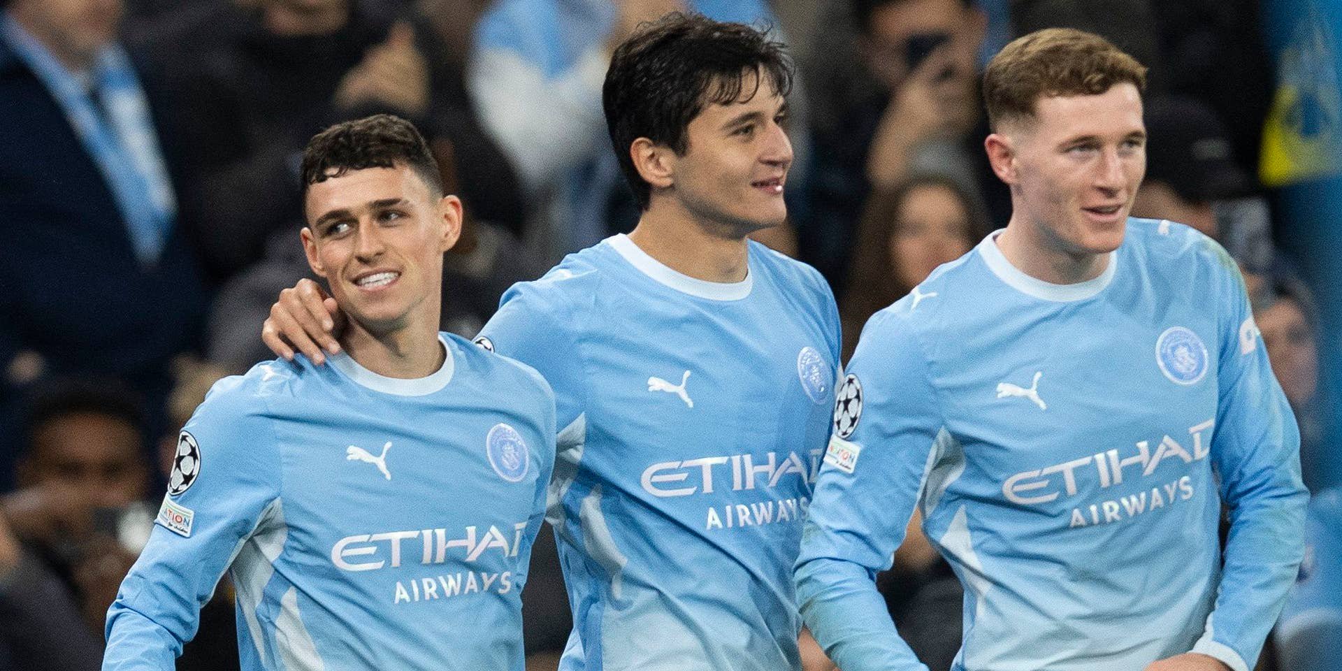 Drei Fußballspieler von Manchester City feiern gemeinsam ein Tor auf dem Spielfeld.