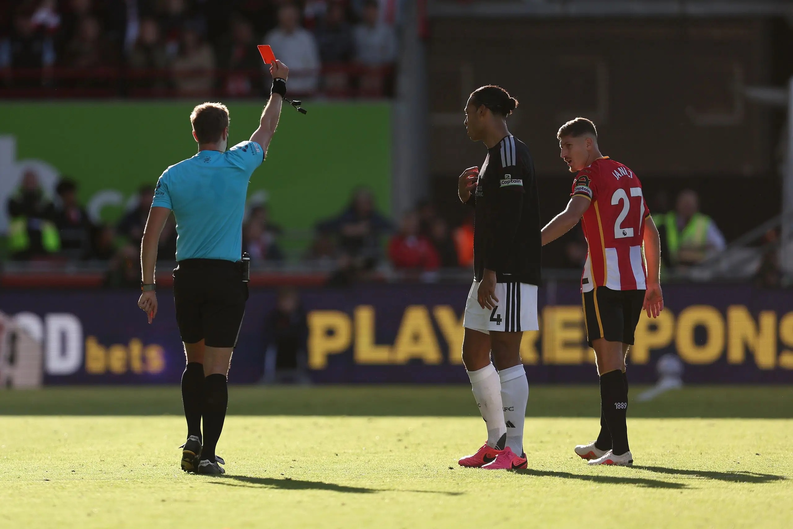 Referee John Brooks waving a red card.