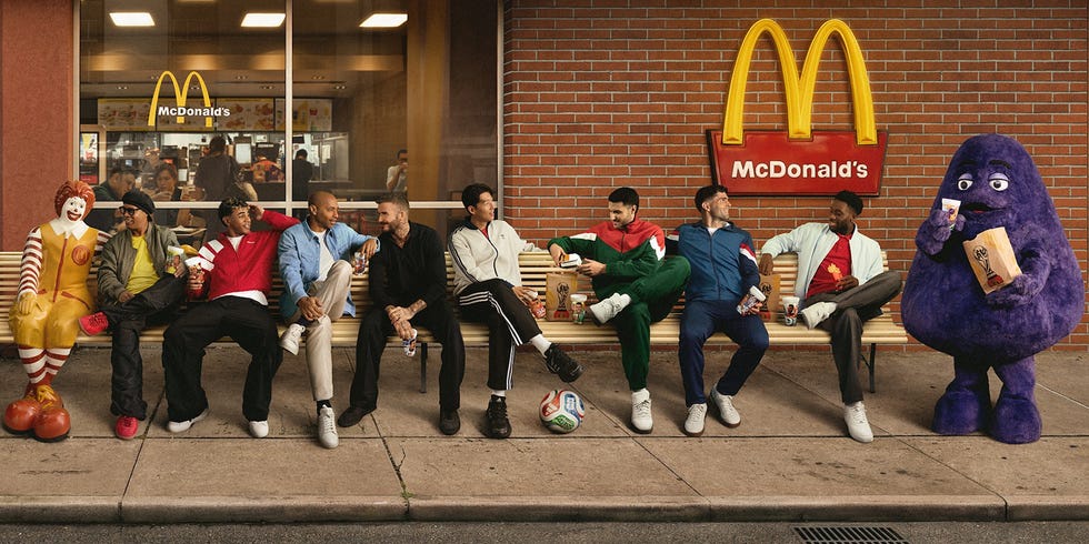 Group sitting on a McDonald's bench with Ronald McDonald and Grimace.