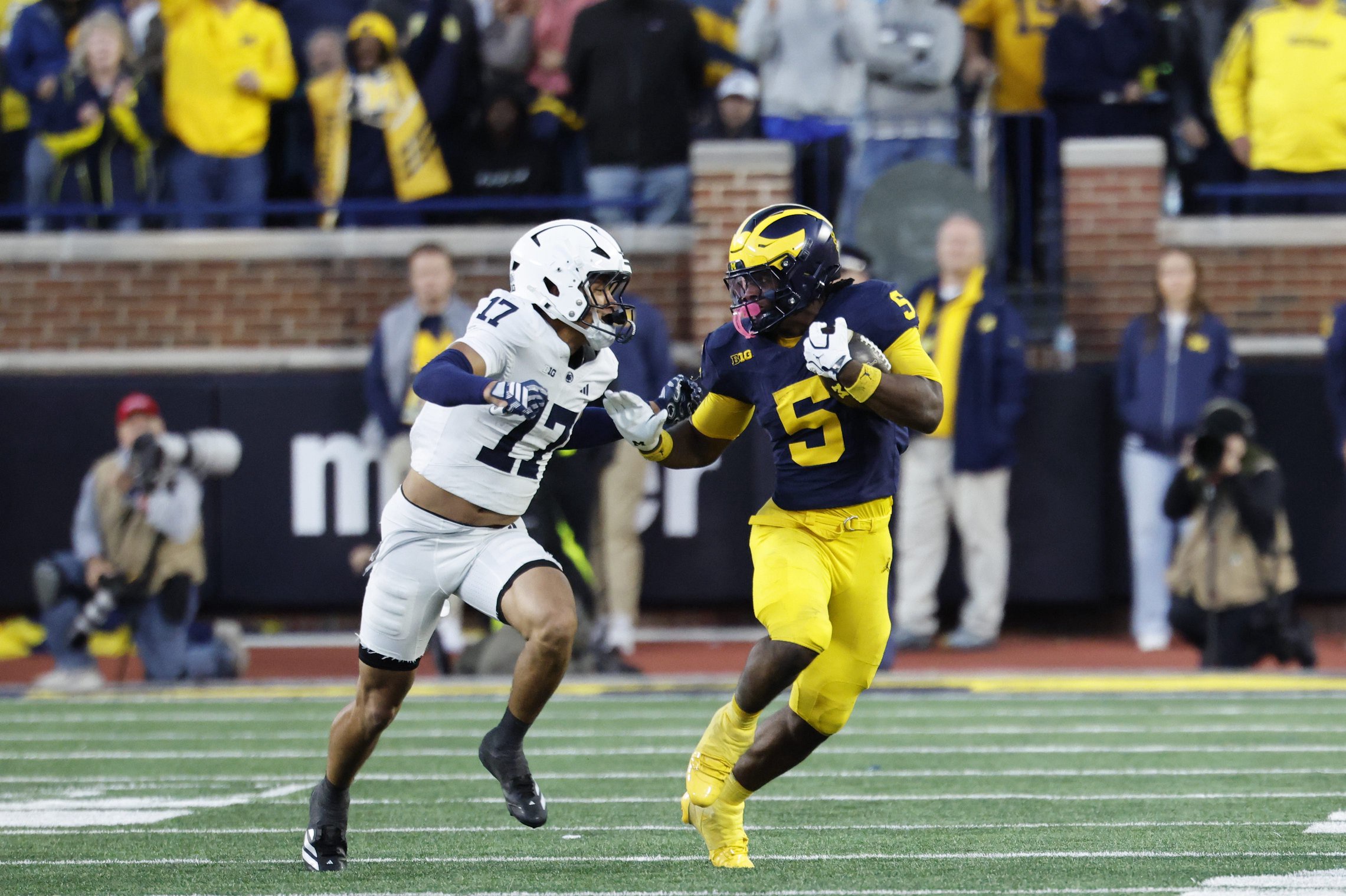 Oct 17, 2026; Ann Arbor, Michigan, USA;  Michigan Wolverines running back Savion Hiter (5) runs the ball pressured by Penn State Nittany Lions cornerback Josiah Zayas (17) at Michigan Stadium.  Mandatory Credit: Rick Osentoski-Imagn Images
