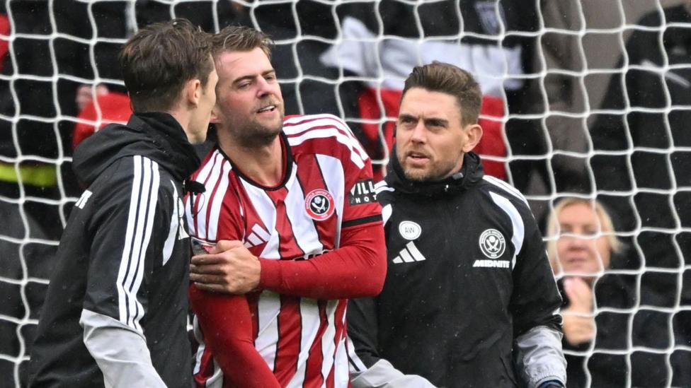 Sheffield United's Patrick Bamford is led from the field after scoring against Derby County.