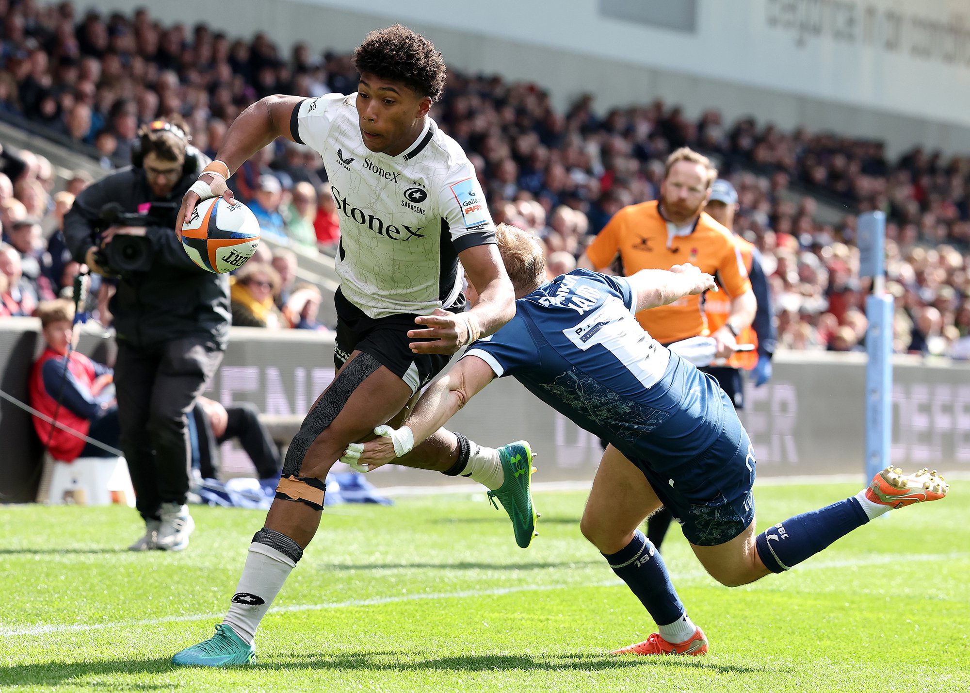 Saracens' Noah Caluori runs past Sale Sharks' Gus Warr during a 2026 PREM Rugby match.