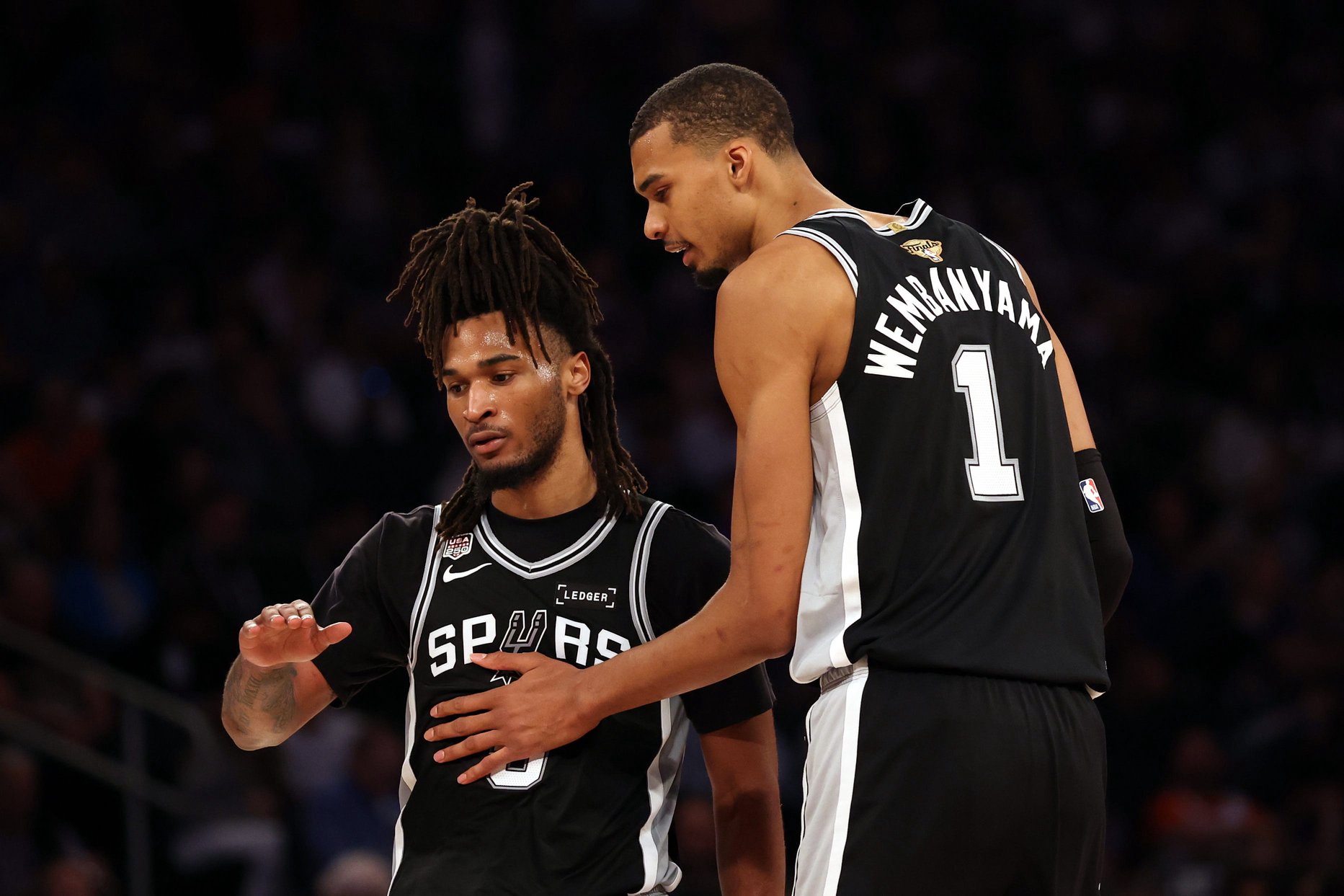 San Antonio Spurs guard Stephon Castle (5) talks with forward Victor Wembanyama (1) against the New York Knicks during game three of the 2026 NBA Finals in the third quarter at Madison Square Garden. 