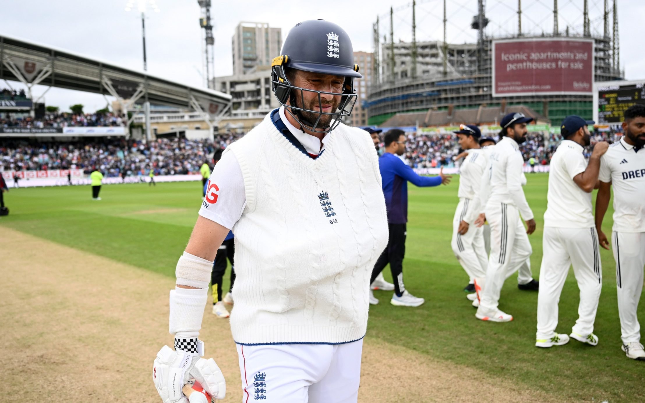 Chris Woakes leaves the field after batting with his arm in a sling