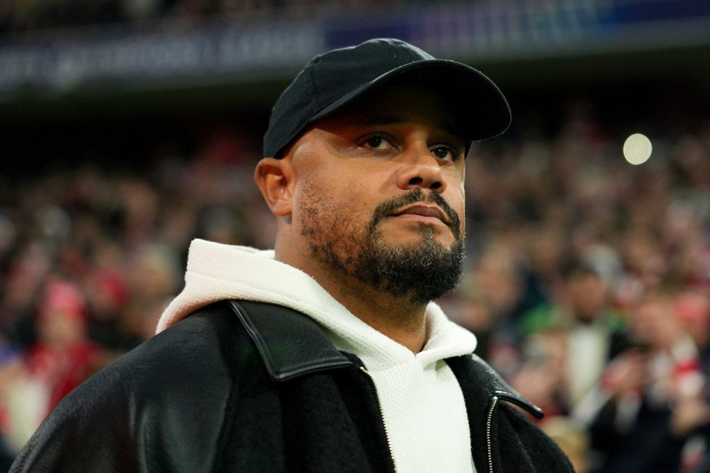 Bayern Munich manager Vincent Kompany wearing a black cap and jacket during a match against Arsenal.
