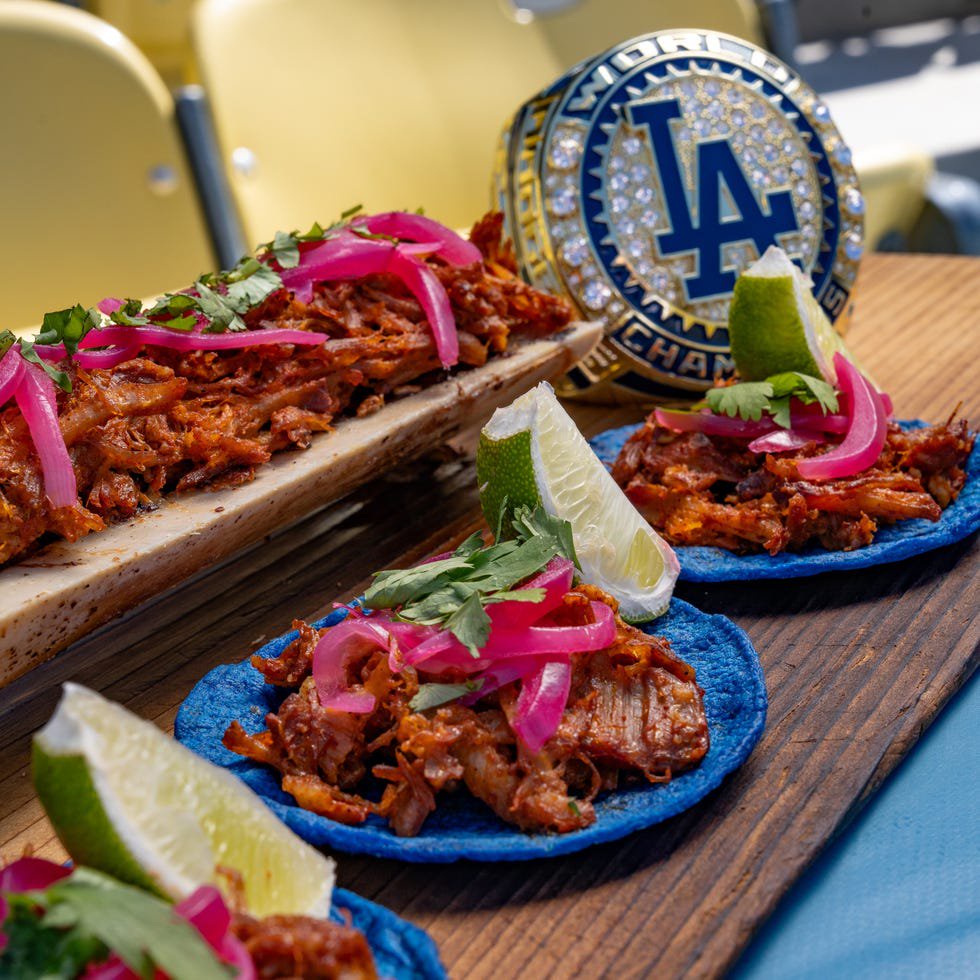 Variety of tacos and a championship ring are displayed on a wooden board.