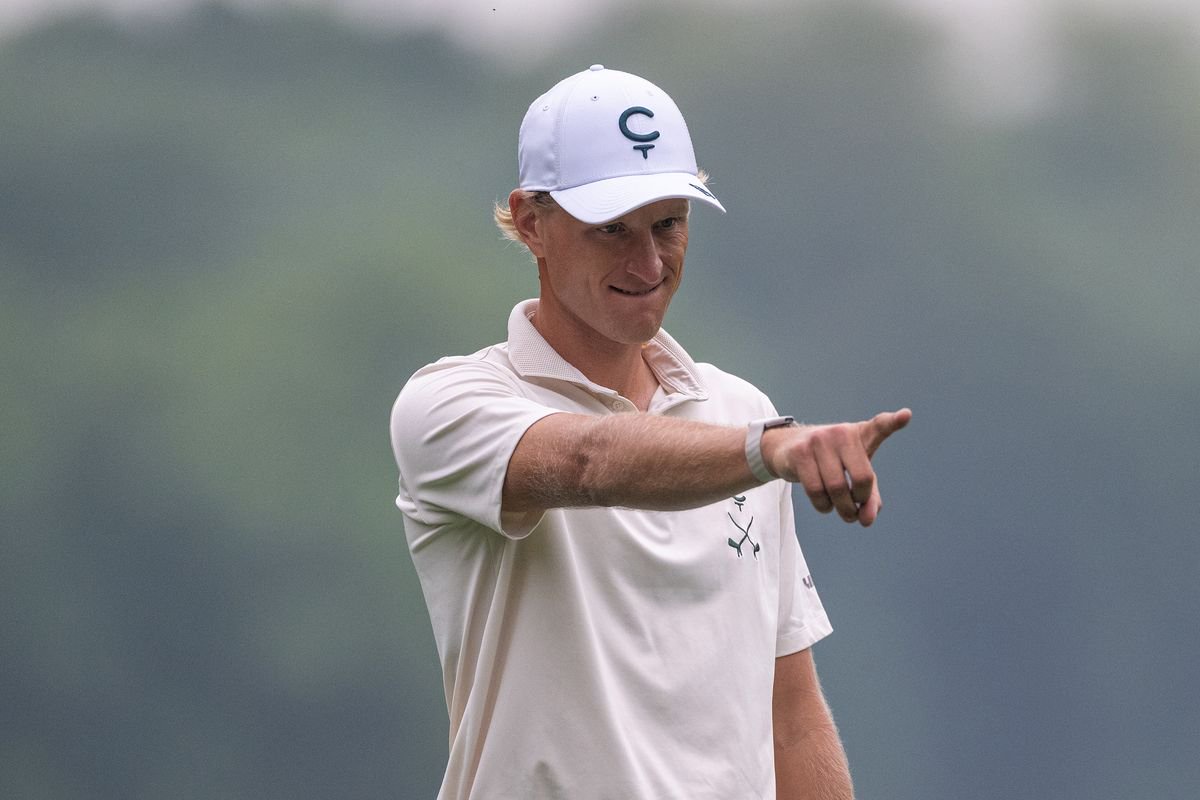Adrian Meronk points his finger while lining up a putt