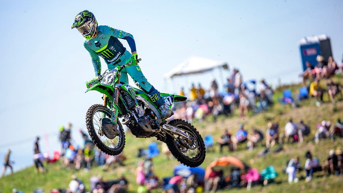 Levi Kitchen performs a jump on his dirt bike while crowd looks on