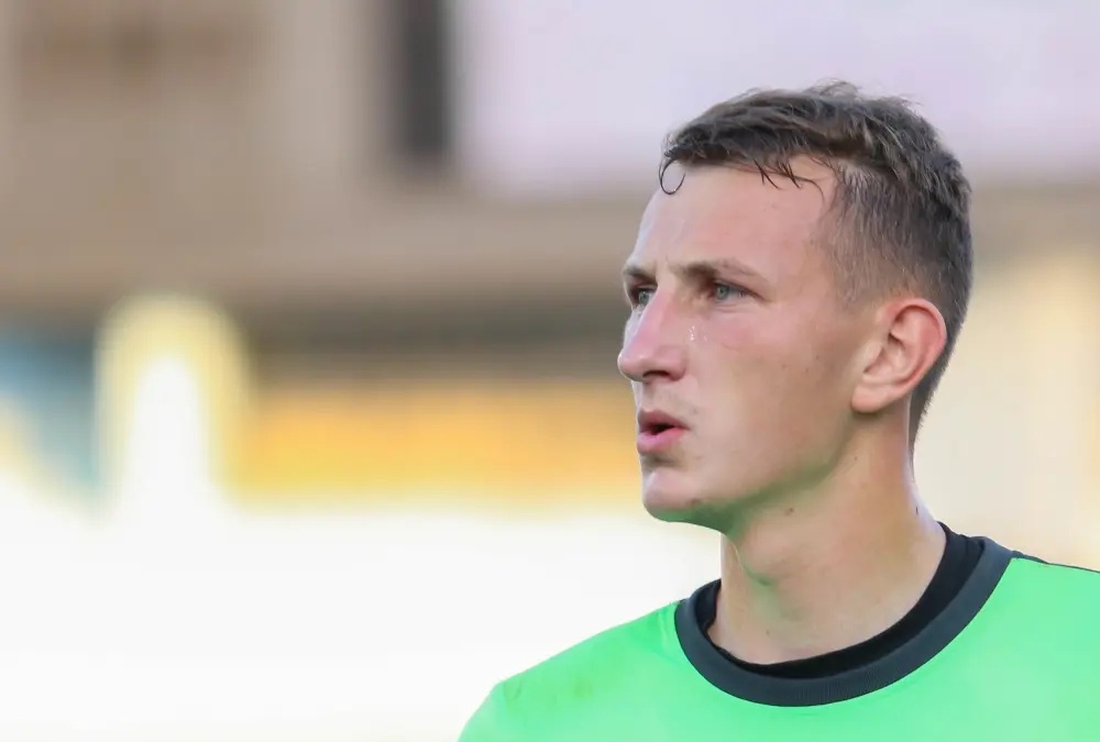 Portrait of Dmytro Riznyk in a green goalkeeper jersey.