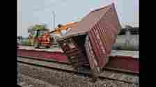 A JCB removing one of the containers that fell off a goods train rake at Taraori station in Karnal district on Tuesday, affecting traffic on the Ambala-Delhi route. (HT Photo)
