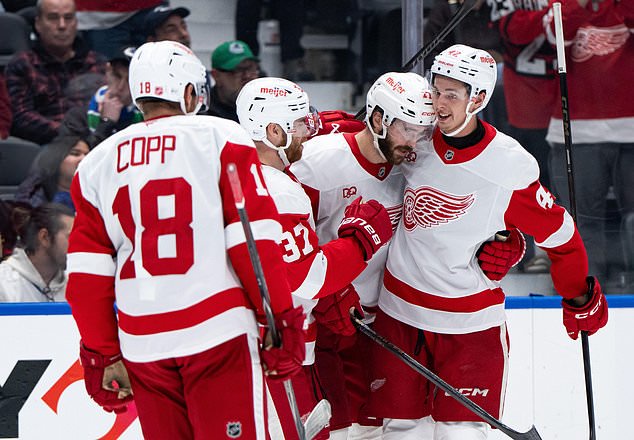 Detroit Red Wings' Anton Johansson, right, celebrates after his goal against the Vancouver Canucks with teammates during the second period of an NHL hockey game in Vancouver, British Columbia, Thursday, Oct. 22, 2026. (Ethan Cairns/The Canadian Press via AP)