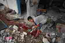 A Palestinian boy checks debris around a pool of blood at a UN school housing displaced people that was hit during Israeli bombardment in Nuseirat, in the central Gaza Strip, on June 6, 2024