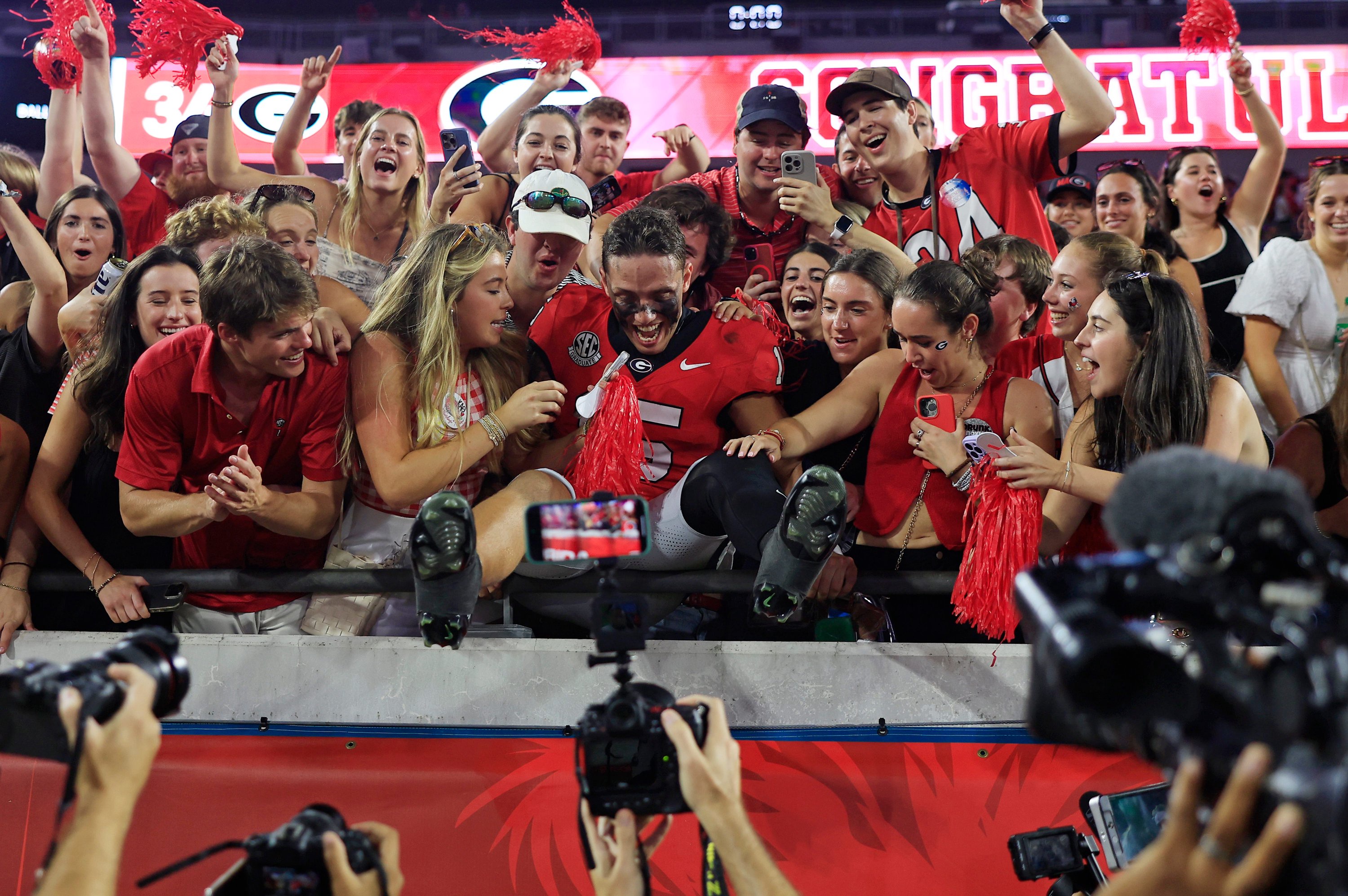 Georgia Bulldogs quarterback Carson Beck (15) jumps into the student section after the game of an NCAA college football matchup Saturday, Nov. 2, 2024 at EverBank Stadium in Jacksonville, Fla. The Georgia Bulldogs defeated the Florida Gators 34-20. [Corey Perrine/Florida Times-Union]