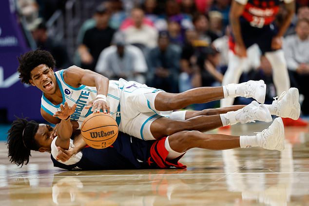 Charlotte Hornets guard Christian Anderson Jr., top, battles Washington Wizards guard Bub Carrington for the ball during the second half of an NBA basketball game in Charlotte, N.C., Monday, Oct. 26, 2026. (AP Photo/Nell Redmond)