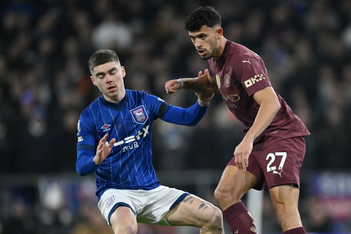 Matheus Nunes of Manchester City is challenged by Leif Davis of Ipswich Town during the Premier League match between Ipswich Town FC and Manchester City FC at Portman Road