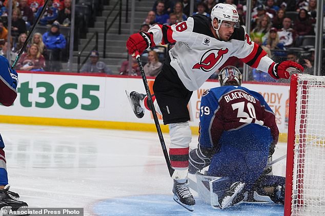 New Jersey Devils right wing Timo Meier, front, avoids Colorado Avalanche goaltender Mackenzie Blackwood as he stops a shot in the second period of an NHL hockey game Wednesday, Oct. 28, 2026, in Denver. (AP Photo/David Zalubowski)