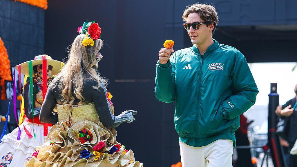 George Russell is handed a flower in the Mexico City paddock 
