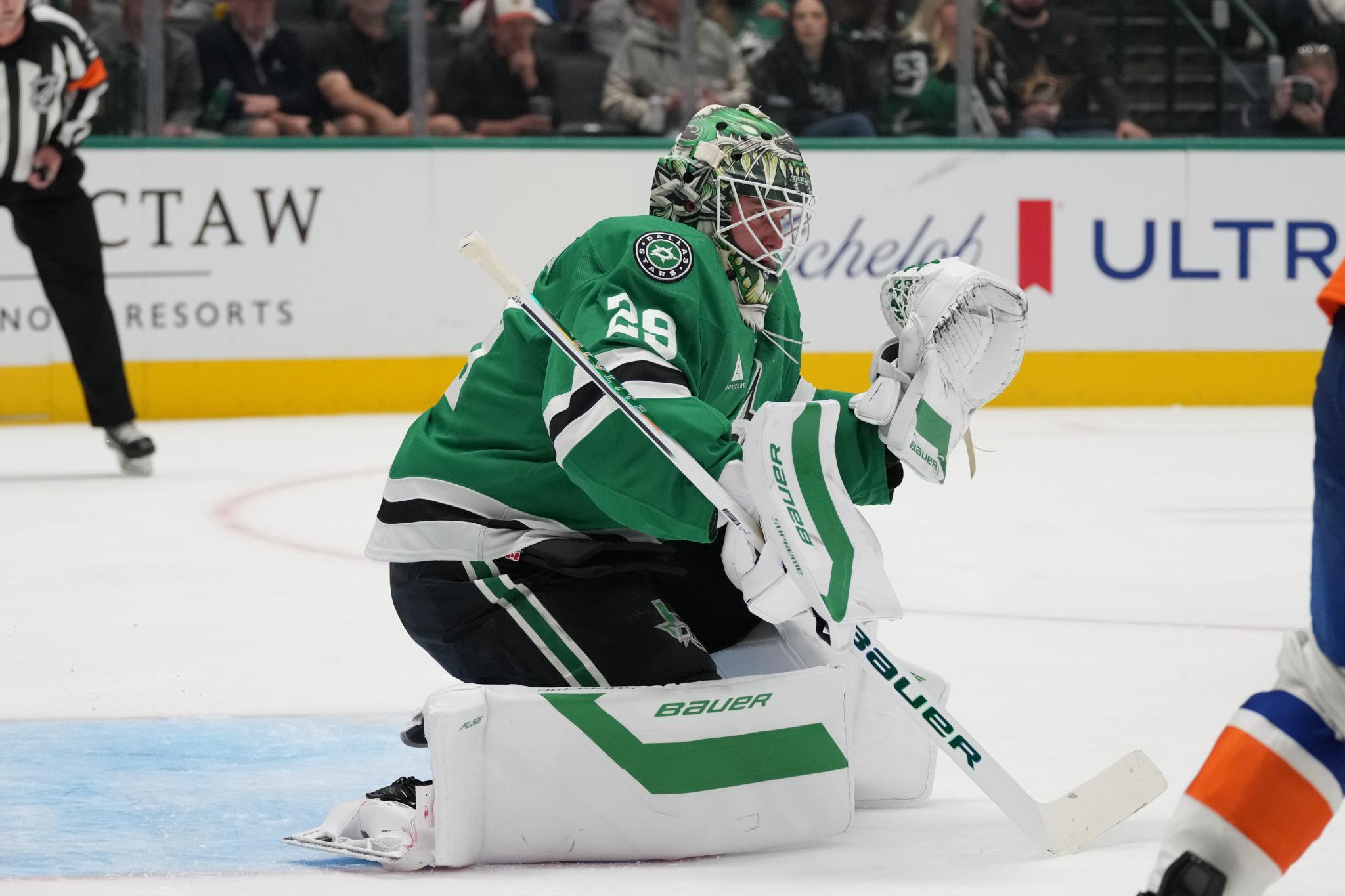Dallas Stars goaltender Jake Oettinger kneels on the ice to block a shot during a game against the New York Islanders.