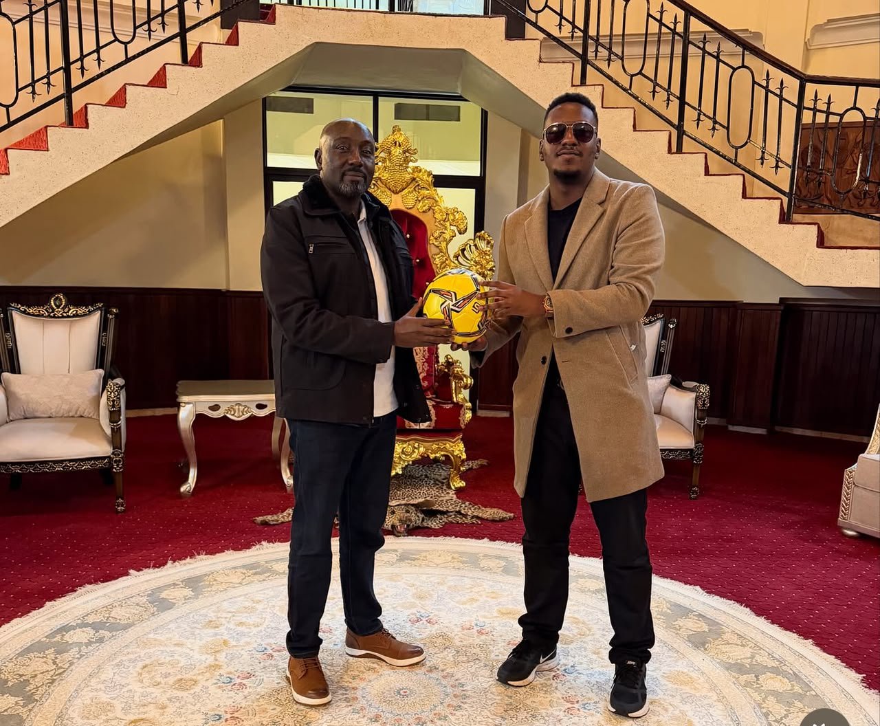 Youth advocate Joshua Baguma (right) presents a football to Omukama of Tooro Edward Rukidi Nyabongo I at Karuziika Palace in Fort Portal City. Baguma donated 50 footballs to the King, who distributed them to teams in the 2026 Tooro Kingdom MTN Amasaza Cup.