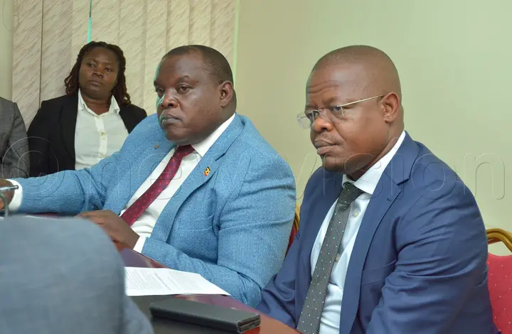 Committee chairperson Moses Magogo (foreground) with Kwania County MP Tony Ayoo follow proceedings. Photo by Edith Namayanja