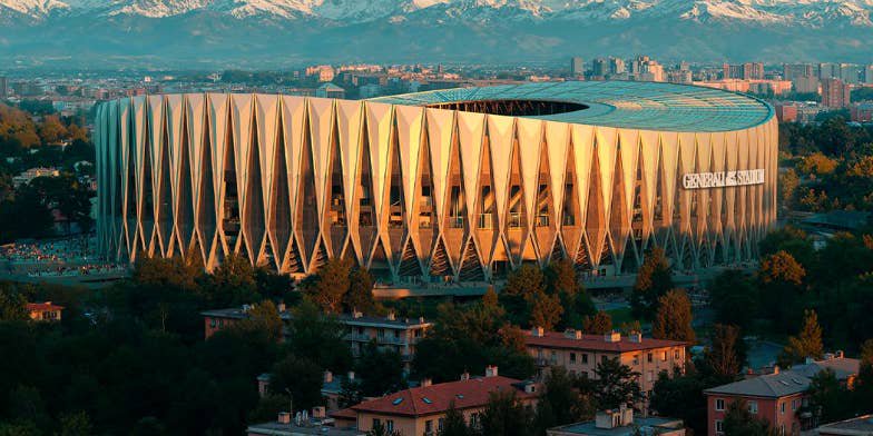 Modernes Stadion mit auffälliger Fassade vor schneebedeckten Bergen und Stadt im Hintergrund.