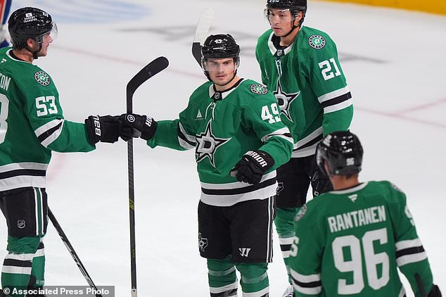 Dallas Stars center Justin Hryckowian (49) celebrates after scoring with teammates Wyatt Johnston (53), Jason Robertson (21) and Mikko Rantanen (96) during the second period of an NHL hockey game against the New York Islanders, Sunday, Oct. 25, 2026, in Dallas. (AP Photo/LM Otero)