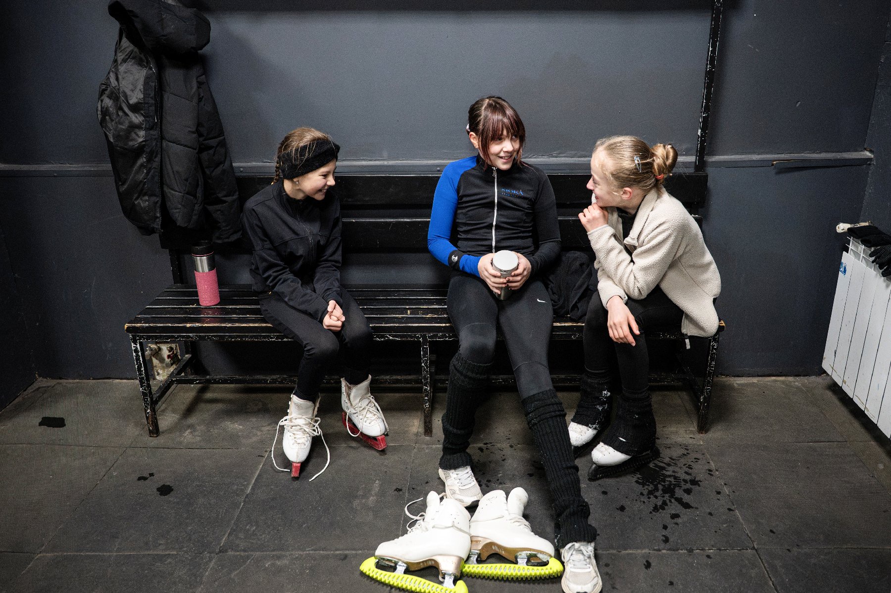 Trois jeunes patineuses prennent une pause lors d'un entraînement dans une patinoire de Kiev, le 16 octobre 2026