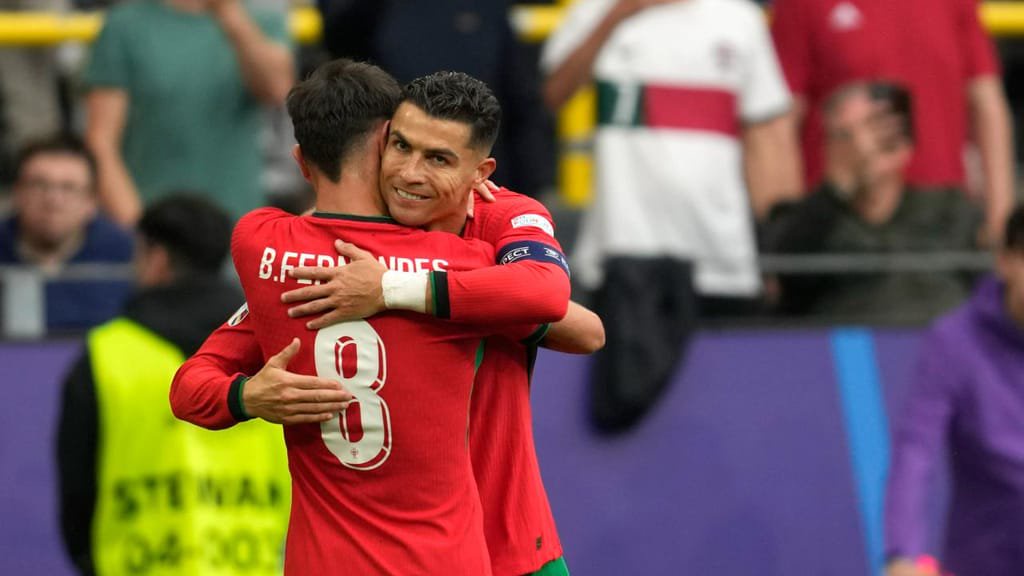 Bruno Fernandes com Cristiano Ronaldo (AP Photo/Darko Vojinovic)